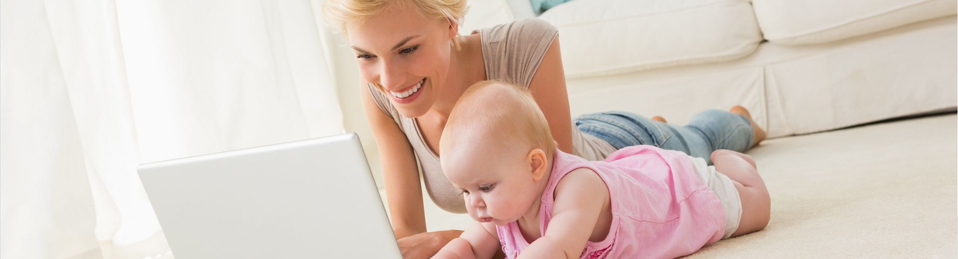 Mutter mit Baby vor einem Laptop